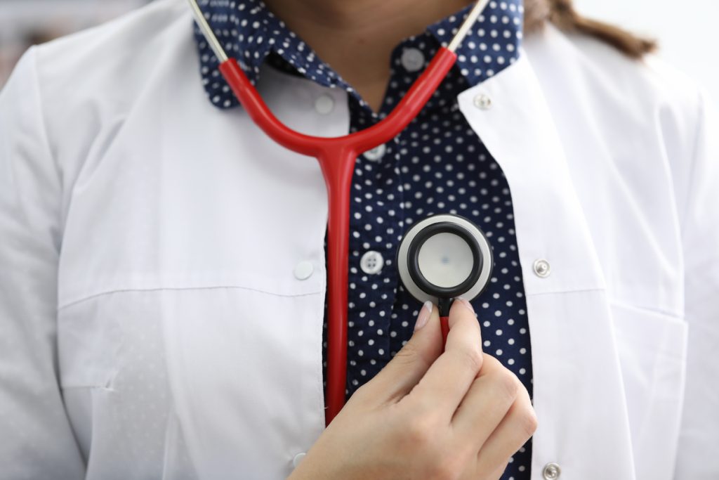 Close-up of female doctor cardiologist investigating heart. Prevention of respiration disease. Modern hospital equipment. Medicine and healthcare concept